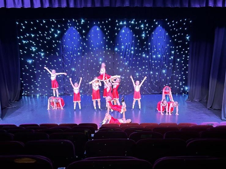Students performing contemporary routine under stage lighting